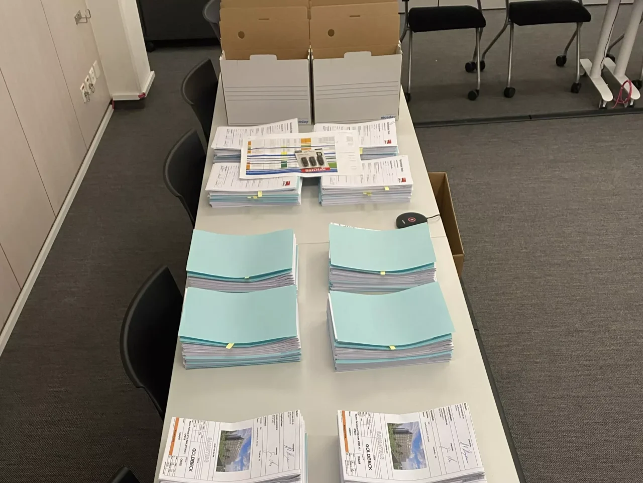 2503_GPS_Parkhaus-Baugesuch_02 Ausdrucke des Baugesuchs, sortiert auf Tischen